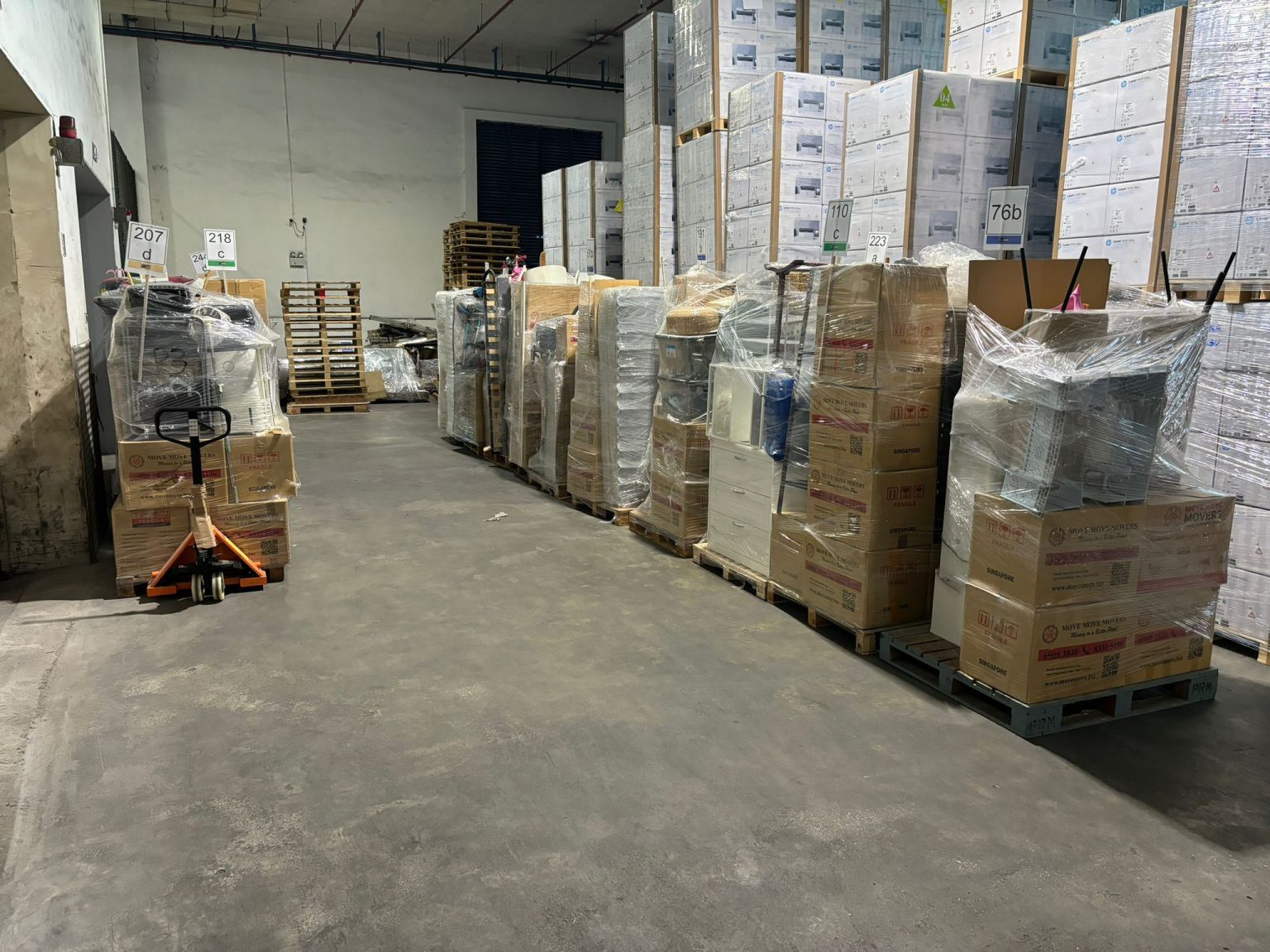 Wrapped and labelled furniture and cartons staged on warehouse pallets